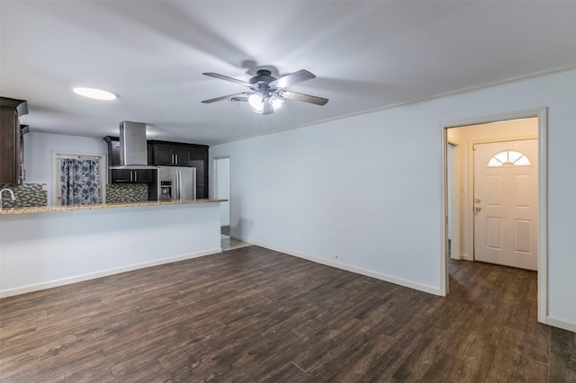 unfurnished living room featuring ceiling fan, sink, dark wood-type flooring, and ornamental molding