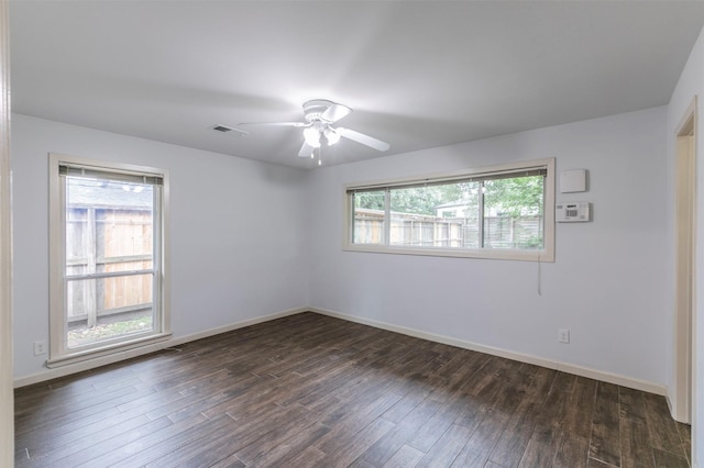 spare room with ceiling fan, dark hardwood / wood-style flooring, and a wealth of natural light