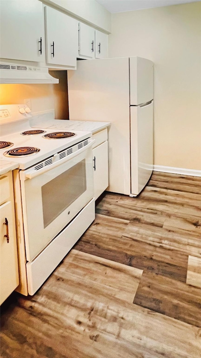 kitchen with white appliances, light hardwood / wood-style floors, and white cabinets