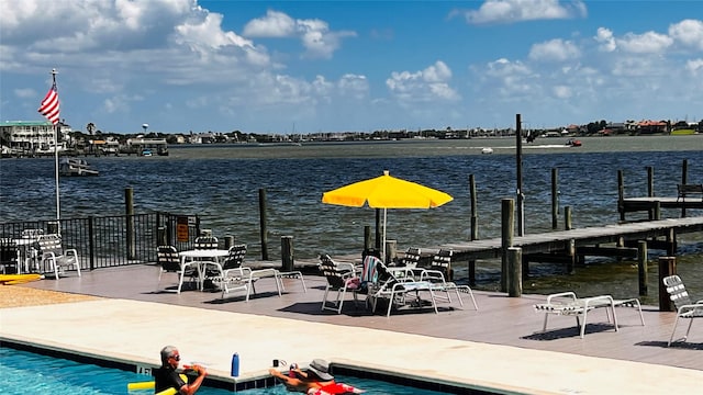 view of dock featuring a community pool and a water view