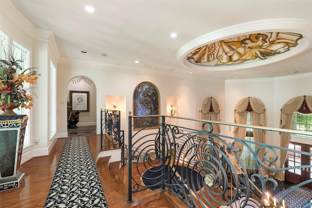 corridor with a healthy amount of sunlight, dark hardwood / wood-style flooring, and ornamental molding