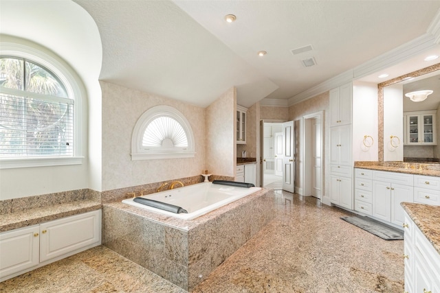 bathroom with vanity, tiled tub, and crown molding