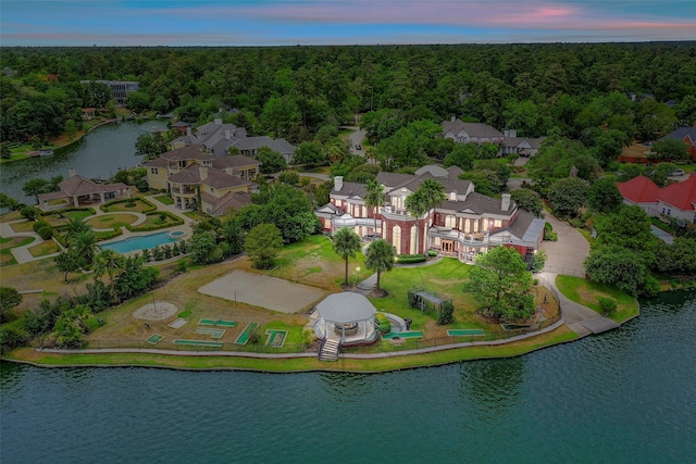 aerial view at dusk featuring a water view