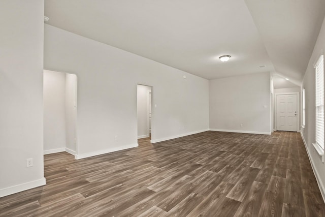 spare room with vaulted ceiling and dark hardwood / wood-style flooring