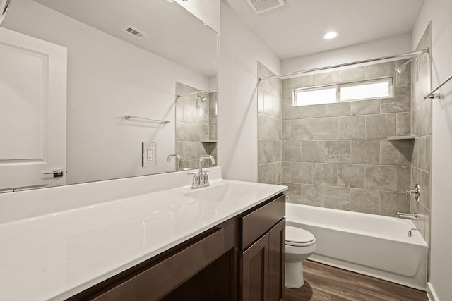 full bathroom featuring vanity, toilet, hardwood / wood-style floors, and tiled shower / bath