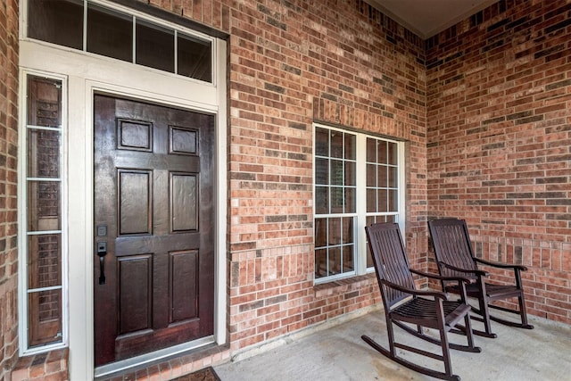 entrance to property featuring brick siding