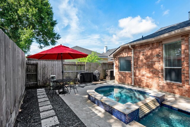 view of swimming pool featuring a patio, an in ground hot tub, and a fenced backyard