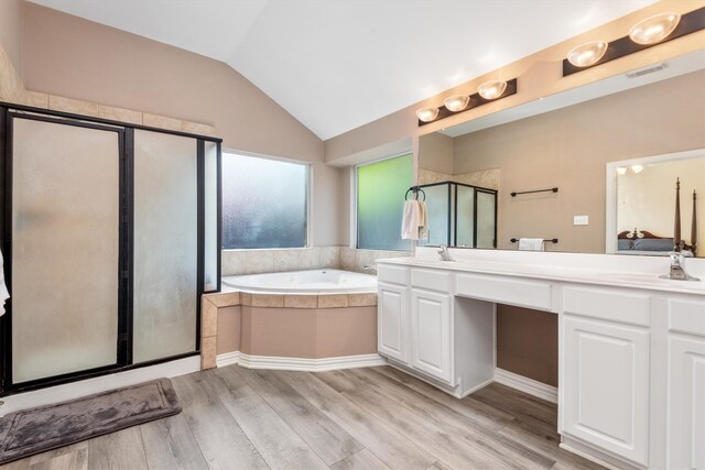 full bathroom with visible vents, a garden tub, a stall shower, a sink, and lofted ceiling