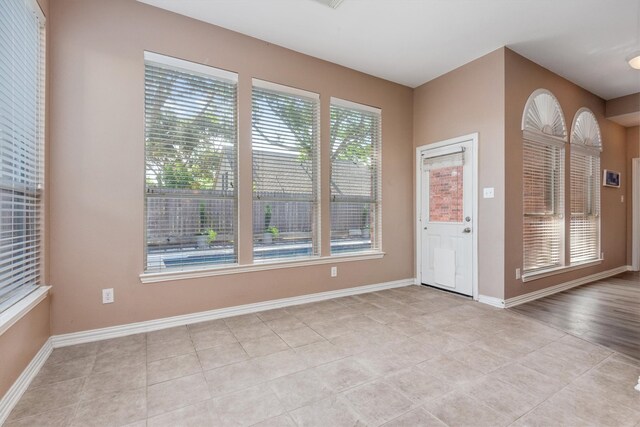 interior space with light tile patterned floors and baseboards