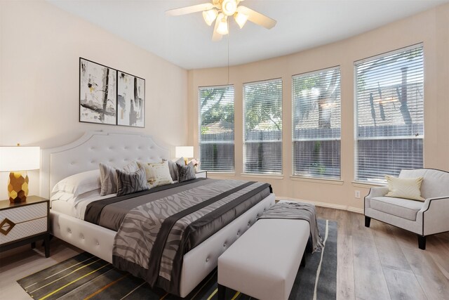 bedroom with baseboards, wood finished floors, and a ceiling fan