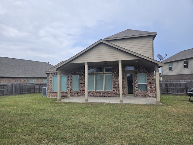 rear view of house with a patio, central air condition unit, and a lawn