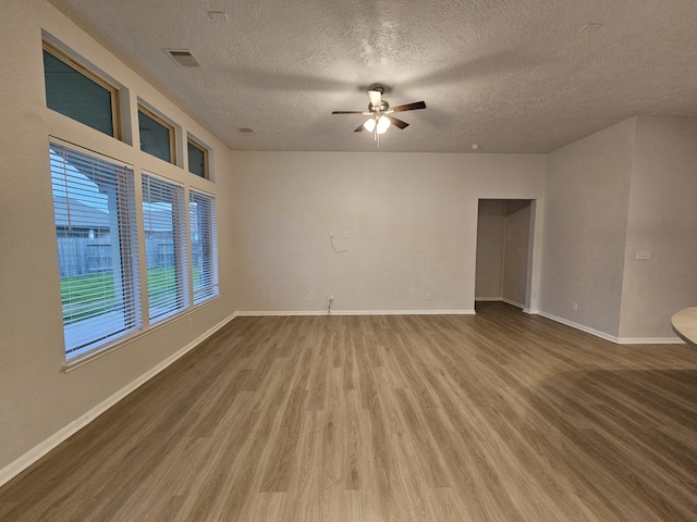 spare room with hardwood / wood-style floors, ceiling fan, and a textured ceiling