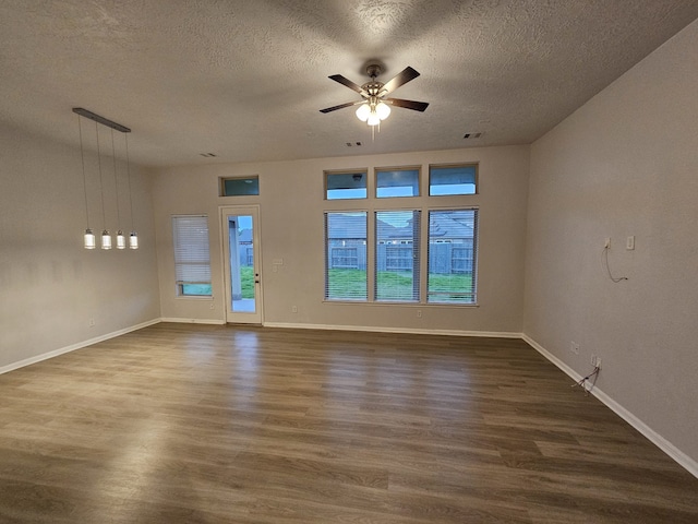 unfurnished room featuring ceiling fan, dark hardwood / wood-style flooring, and a textured ceiling