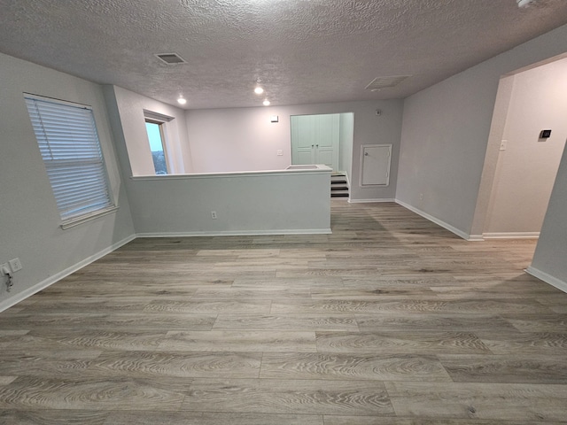 empty room featuring a textured ceiling and light hardwood / wood-style flooring