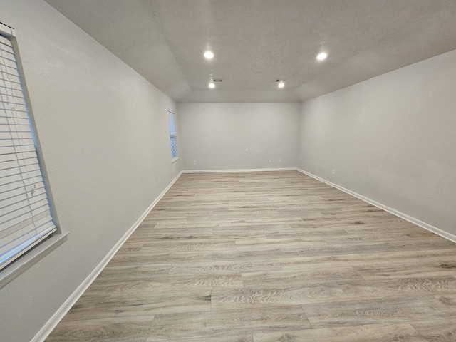 spare room featuring a textured ceiling and light hardwood / wood-style flooring