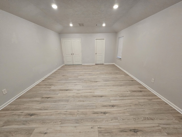 empty room featuring light hardwood / wood-style floors and a textured ceiling