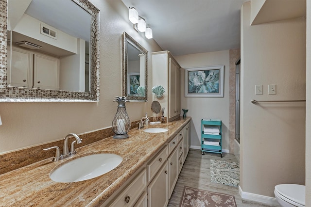 full bathroom featuring wood-type flooring, vanity, toilet, and enclosed tub / shower combo