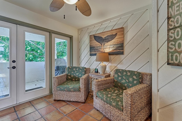 living area with wooden walls, plenty of natural light, and french doors