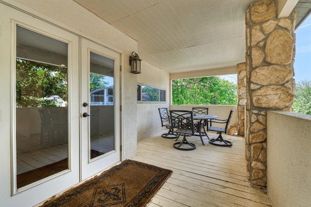 wooden terrace featuring french doors and a porch