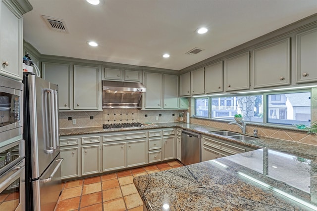 kitchen with gray cabinetry, stainless steel appliances, sink, light tile patterned floors, and stone counters