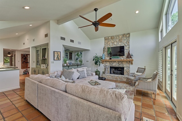 living room with a fireplace, light tile patterned floors, high vaulted ceiling, and ceiling fan