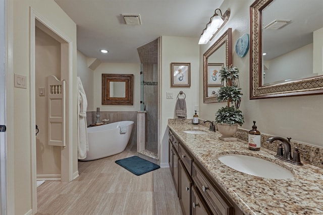 bathroom with hardwood / wood-style flooring, vanity, and independent shower and bath