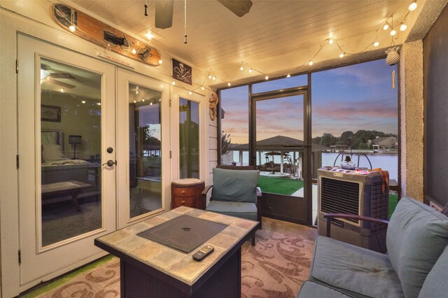 sunroom / solarium featuring a water view and wooden ceiling