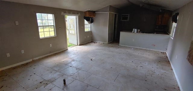 unfurnished living room with light tile patterned floors and vaulted ceiling