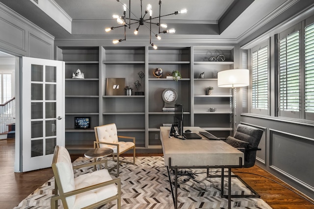 office area featuring wood-type flooring, an inviting chandelier, built in features, and a tray ceiling