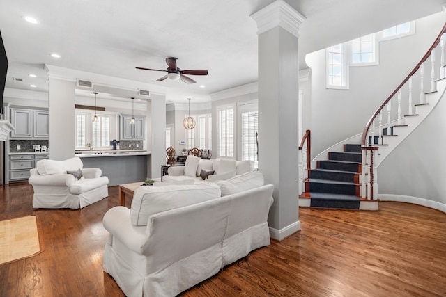 living room with ceiling fan with notable chandelier, a healthy amount of sunlight, and dark hardwood / wood-style flooring