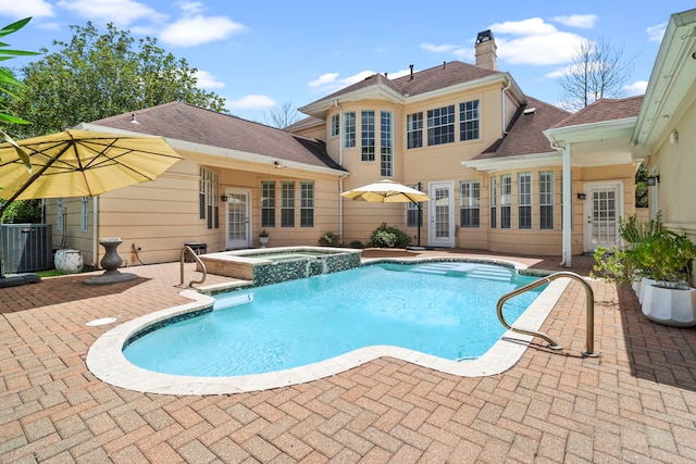 view of pool featuring an in ground hot tub, french doors, a patio area, and central air condition unit