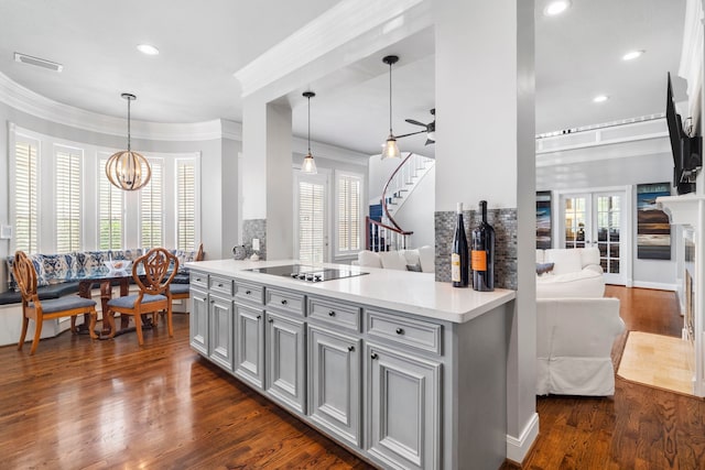 kitchen featuring dark wood-type flooring, a healthy amount of sunlight, black electric stovetop, and pendant lighting