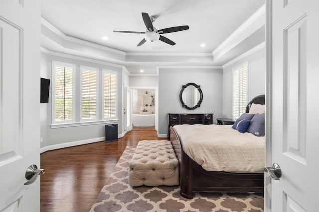 bedroom featuring dark hardwood / wood-style flooring, a raised ceiling, ceiling fan, and connected bathroom