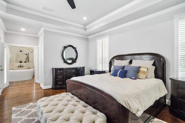 bedroom featuring ensuite bath, ceiling fan, dark hardwood / wood-style flooring, and multiple windows