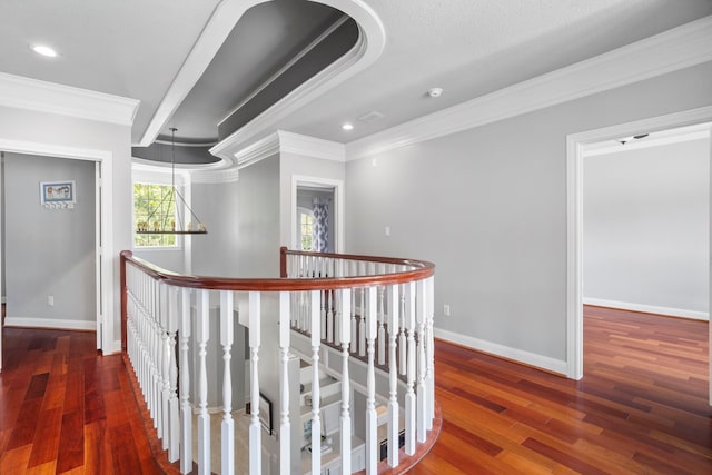 hallway with dark hardwood / wood-style floors, an inviting chandelier, and crown molding