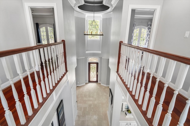 foyer entrance featuring crown molding and an inviting chandelier