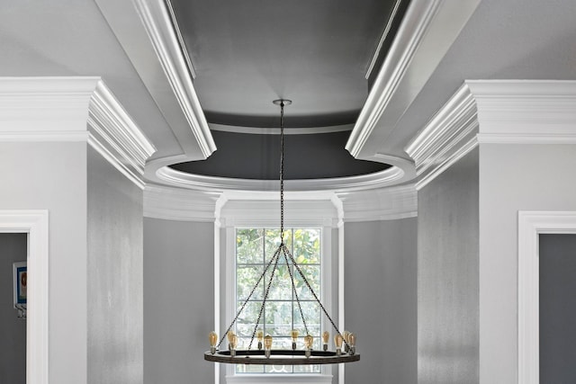 interior details featuring a raised ceiling and ornamental molding