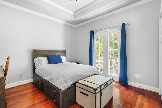 bedroom with a raised ceiling, dark hardwood / wood-style flooring, french doors, and ornamental molding