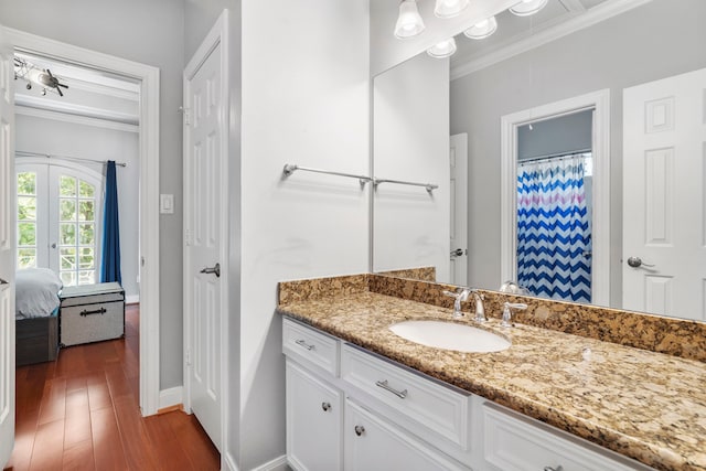 bathroom featuring hardwood / wood-style floors, vanity, and ornamental molding