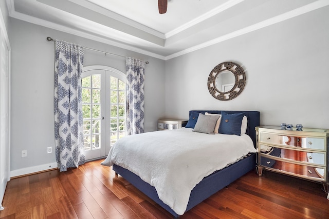 bedroom featuring ceiling fan, french doors, a raised ceiling, dark hardwood / wood-style floors, and ornamental molding