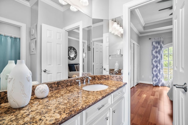 bathroom with hardwood / wood-style floors, vanity, and crown molding