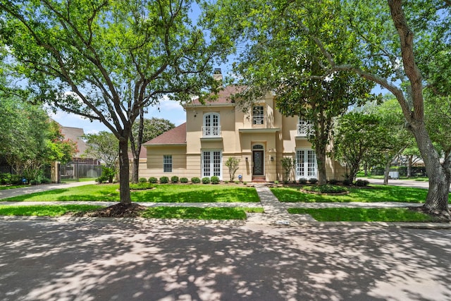 mediterranean / spanish-style home featuring french doors and a front yard