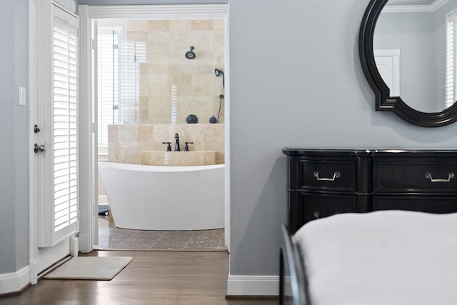 bathroom featuring hardwood / wood-style floors, ornamental molding, and a tub