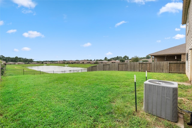 view of yard featuring central AC unit and a water view