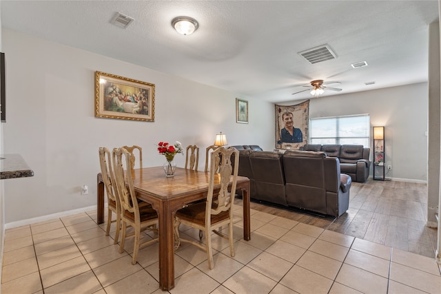 dining room featuring light tile patterned flooring, a textured ceiling, and ceiling fan