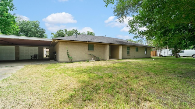 rear view of house with a yard, a garage, and a carport