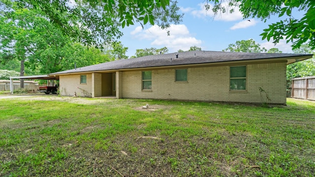 back of house featuring a carport and a yard