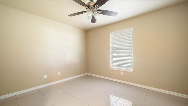 empty room with ceiling fan and light tile patterned flooring