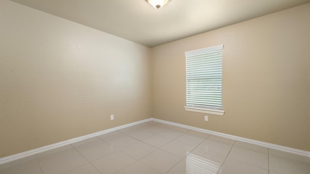 tiled spare room with a healthy amount of sunlight