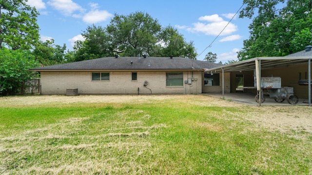 back of house with central AC unit, a patio area, and a yard